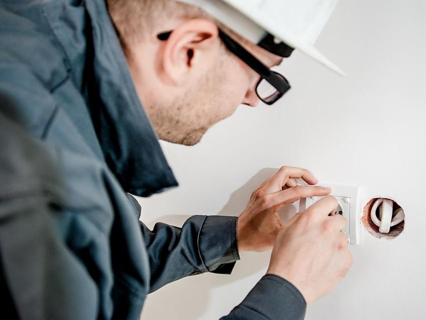 Montaż gniazda elektrycznego w ścianie podczas wykonywania instalacji